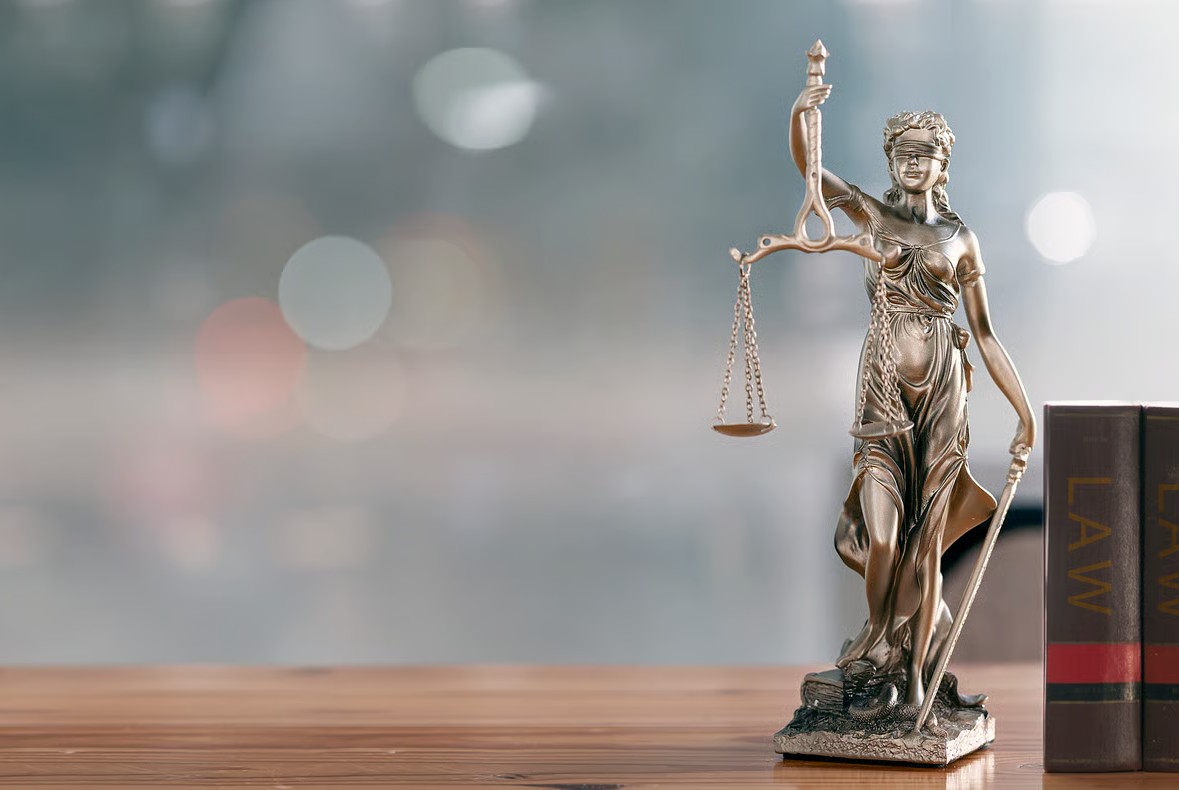 Estatua de la justicia con balanza y espada en un entorno de oficina