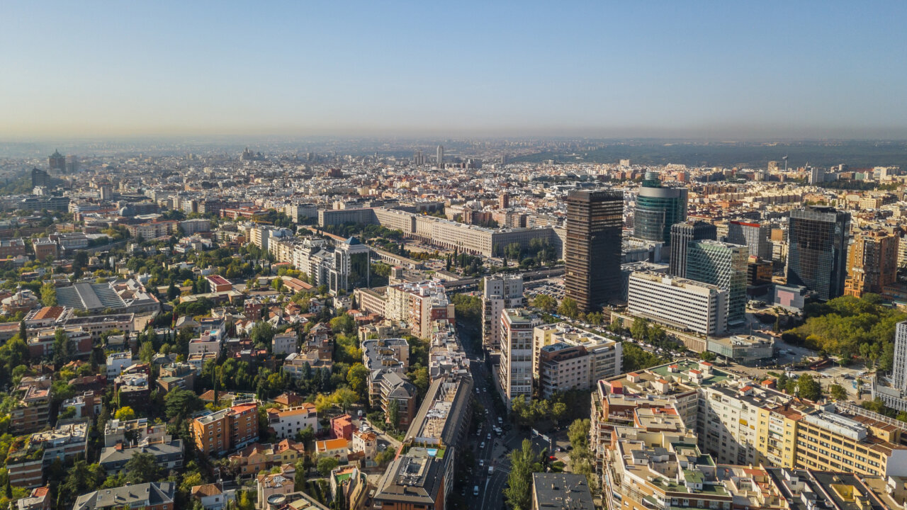 Vista panorámica de la ciudad de Madrid con edificios modernos y áreas verdes.