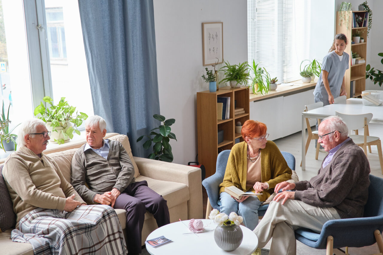 Grupo de personas mayores conversando en una residencia