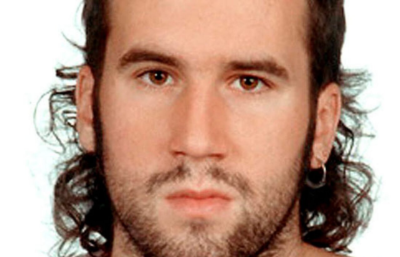 Retrato de un hombre con cabello rizado y arete en la oreja
