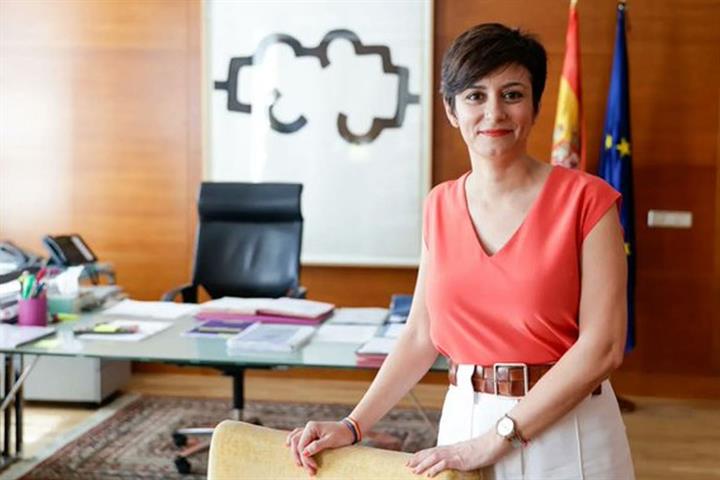 Isabel Rodríguez en su oficina, vestida con blusa naranja.