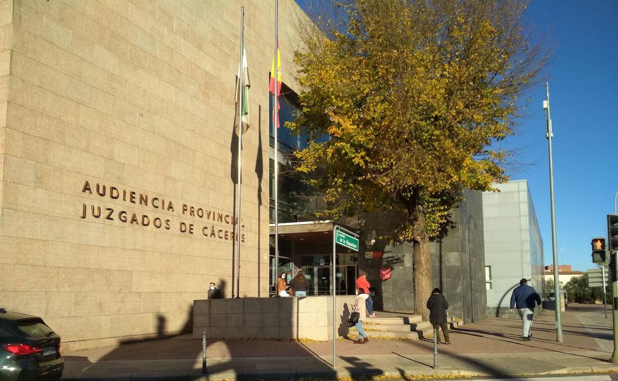 Fachada de la Audiencia Provincial de Cáceres con árboles y banderas